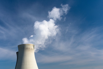 Close up of the steaming cooling towers of Doel in East Flanders Belgium with a blue cloudy sky