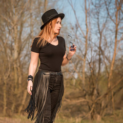 Fashionable outfit details, plus size girl with Large size in fringe belt and fedora hat mix style