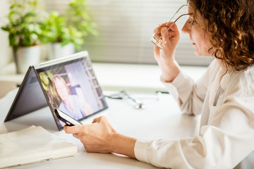 telemedicine concept elderly woman using laptop and taking her blood pressure
