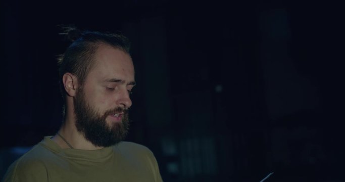 Charismatic actor reads a role from the script in a dark theater near the stage