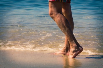 Fototapeta na wymiar man's legs by the beach shore