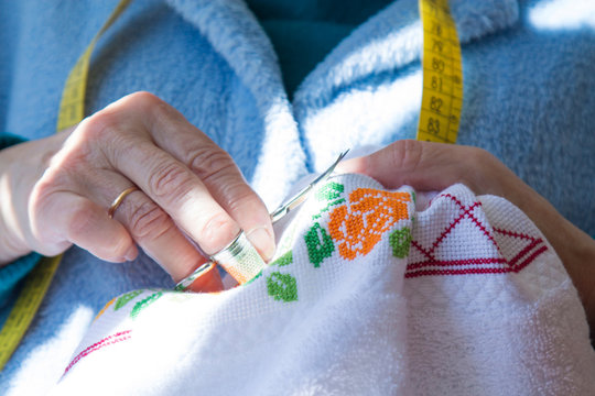 Woman Sewing Cross Stitch A Tablecloth Sitting At Home