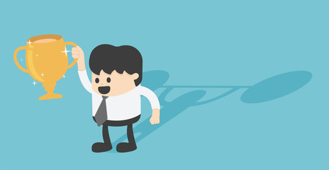 Young Businessman holds golden trophy of victory, shadow on the back that shows strength