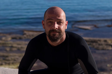 underwater photographer with a scuba cam wearing a neopren swimming suit and fins getting ready for diving. Scuba gear concept.  Water sports photos. Scuba diving resources. 