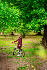 girl with Bicycle in spring Park. 