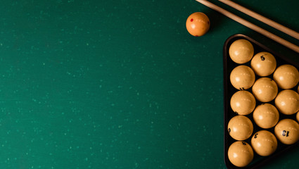 Billiard balls and cue on the billiard table, top view, flat lay