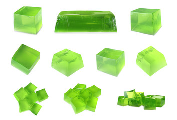 Set of delicious green jelly cubes on white background