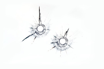 two bullet hole in glass close up on white background © sandsun