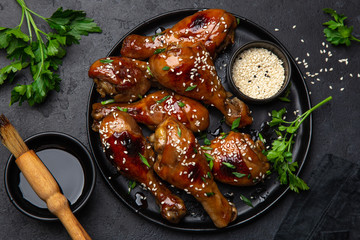 spicy teriyaki chicken legs on black plate