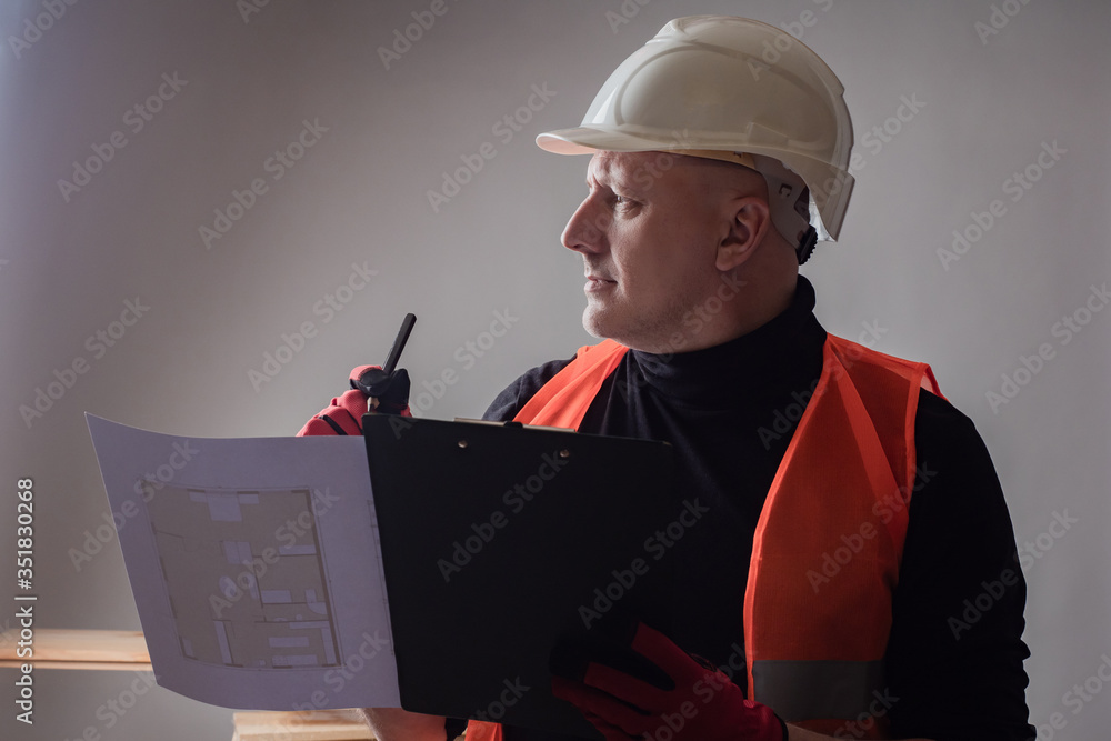 Poster the engineer studies the documentation for the building under co