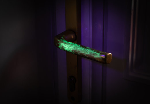 Bacteria or virus visualisation showing transmission on door handle under UV light. 