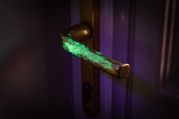 Bacteria or virus visualisation showing transmission on door handle under UV light. 