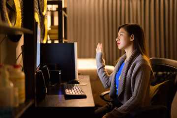 Young Asian woman video calling while working from home
