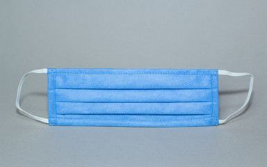 Eine blaue Gesichtsmaske auf grauem Hintergrund, Corona Virus, Covid 19