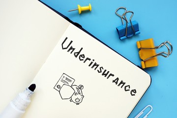 Business concept meaning Underinsurance with inscription on the sheet.