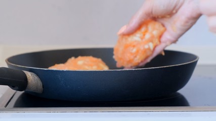 Cutlets fried in a black pan on the stove.