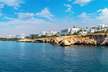 Fototapeta premium Cyprus beach. Ayia Napa Resort. Hotels near beaches of Cyprus. Rocky coast of Ayia Napa resort. Landscapes of the Cyprus coast. Holidays in the Mediterranean. Hotel buildings near the shore