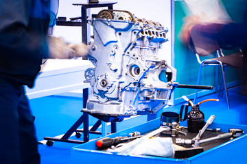 Mechanic disassembles the engine. Disassembled engine next to the repairman. Car repair. Concept - technical inspection of the engine. A man is cleaning a car motor. Prevention. Career car mechanic