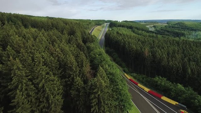 Low flyover trees as cars drive on Spa circuit, Belgium