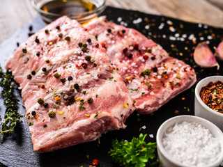 Raw pork ribs on black stone cutting board
