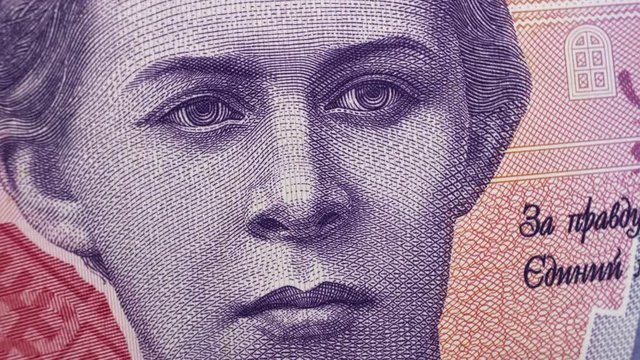 Ukrainian poetess Lesya Ukrainka on 200 UAH banknote rotating. Ukrainian currency, money. Top view, macro.