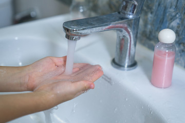 Children wash their hands with liquid soap.