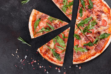 Fresh pizza baked in oven with arugula, salami, cherry tomatoes and mozzarella