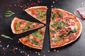 Fresh pizza baked in oven with arugula, salami, cherry tomatoes and mozzarella