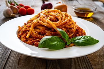 Spaghetti with tomato sauce, meat and parmesan on wooden background
