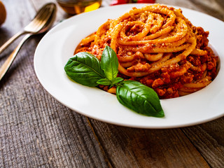 Spaghetti with tomato sauce, meat and parmesan on wooden background
