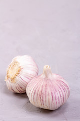 Three heads of garlic close-up on a gray background