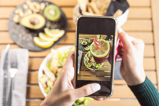 Top view female hands taking photo with mobile smartphone on health lunch food - Young person having fun with new technology apps for social media - Healthy people lifestyle and tech addicted concept