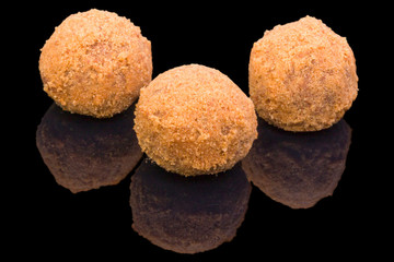 Gourmet truffles balls with honey, isolated on black background, with reflection