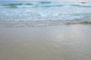 Clean waves on the sea beach with white bubbles for background texture 