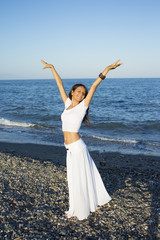 Fototapeta na wymiar Attractive woman in white dress on the beach