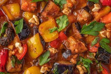 Homemade vegetable stew of eggplant, zucchini, tomatoes, peppers, prunes and greens. Close up food background