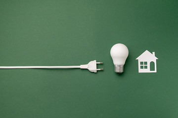 Save energy concept. Creative top view flat lay of LED light bulb, electrical plug, paper white...