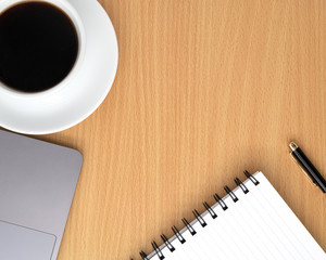 Flat lay, Office table wooden desk, Bright Creative workspace with a black pen, black coffee, lab-top, and blank notebook, Top view with copy space