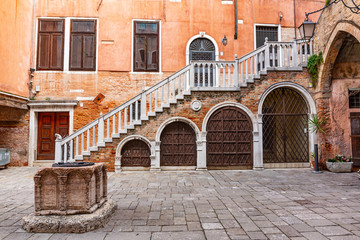 Typical Venetian historical family courtyard with a well and outside staircase.