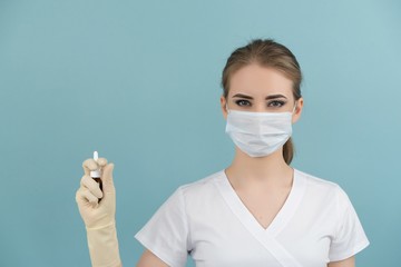 masked doctor holding an aerosol in his hands on a blue background
