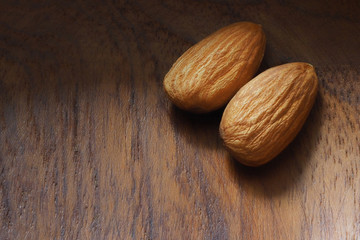 Two almonds on a wooden surface close-up