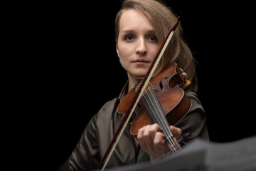Attractive professional female violinist on black