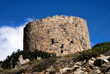 Fototapeta na wymiar Ruins of old traditional windmill at Olympos village in Karpathos island, Greece.