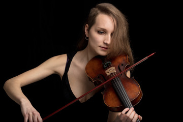 Trendy modern female violinist playing in concert