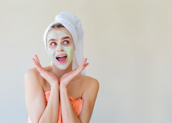 Beauty mask at home. Smiling woman with a facial beauty mask and towel on her head. Copy space for text