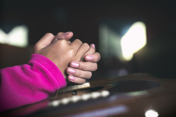 Girl praying on acoustic guitar in the morning, Close up hands, Prayer concept for faith,spirituality,worship and religion.