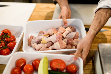 White plastic boxes with vegetables and chicken.