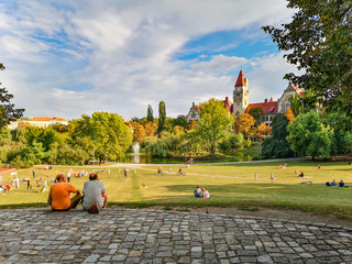 People sitting and playing in Wroclaw Tolpa Park at sunny day - obrazy, fototapety, plakaty
