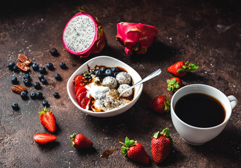 chia bowl with strawberries, blueberries, fruits and nuts on a brown background