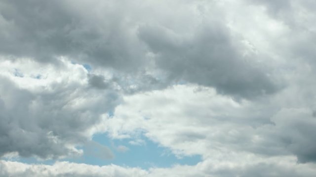 White and gray clouds floating across the blue sky, time lapse